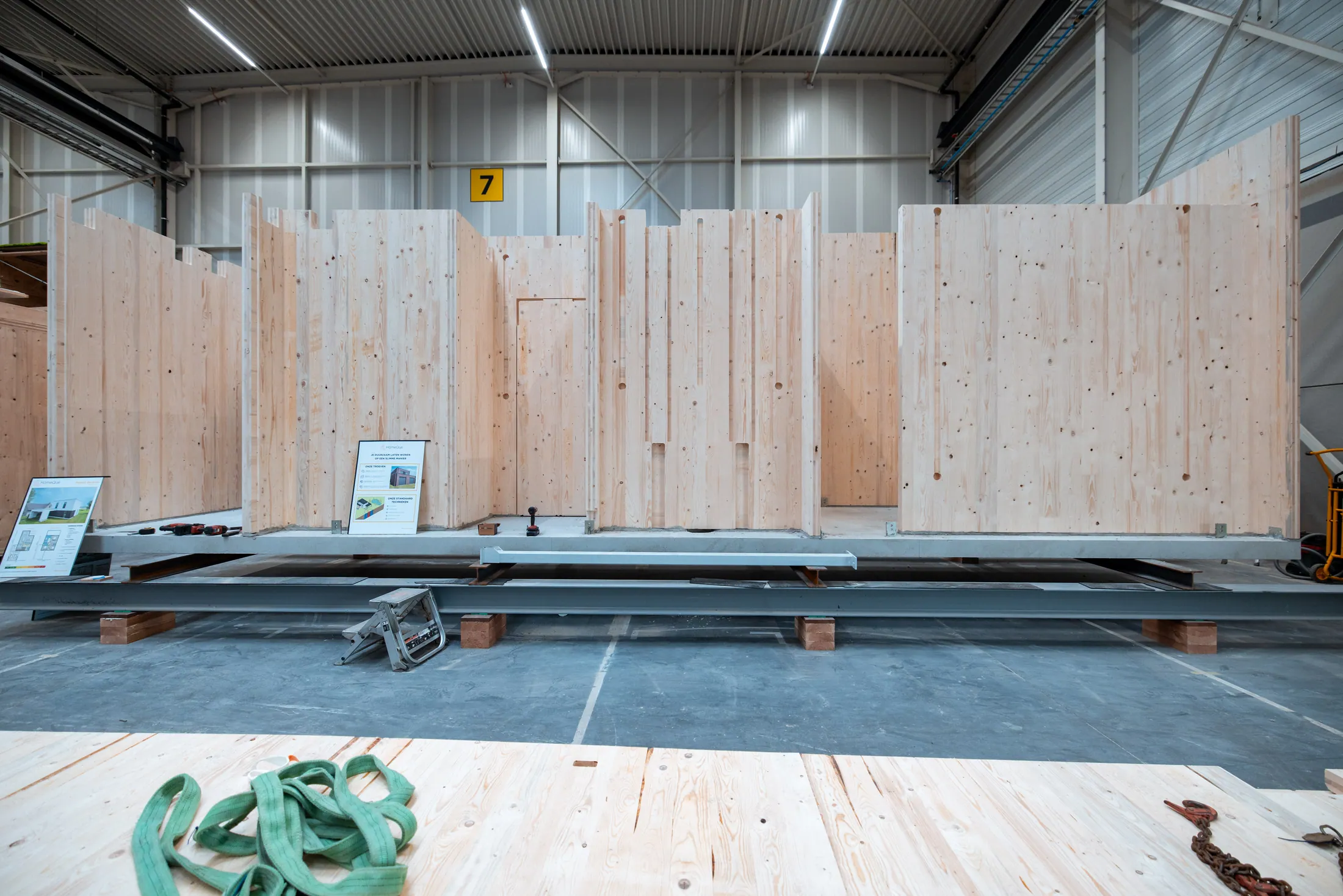 Vakmensen monteren een CLT-wand in de HomeQue-productiehal